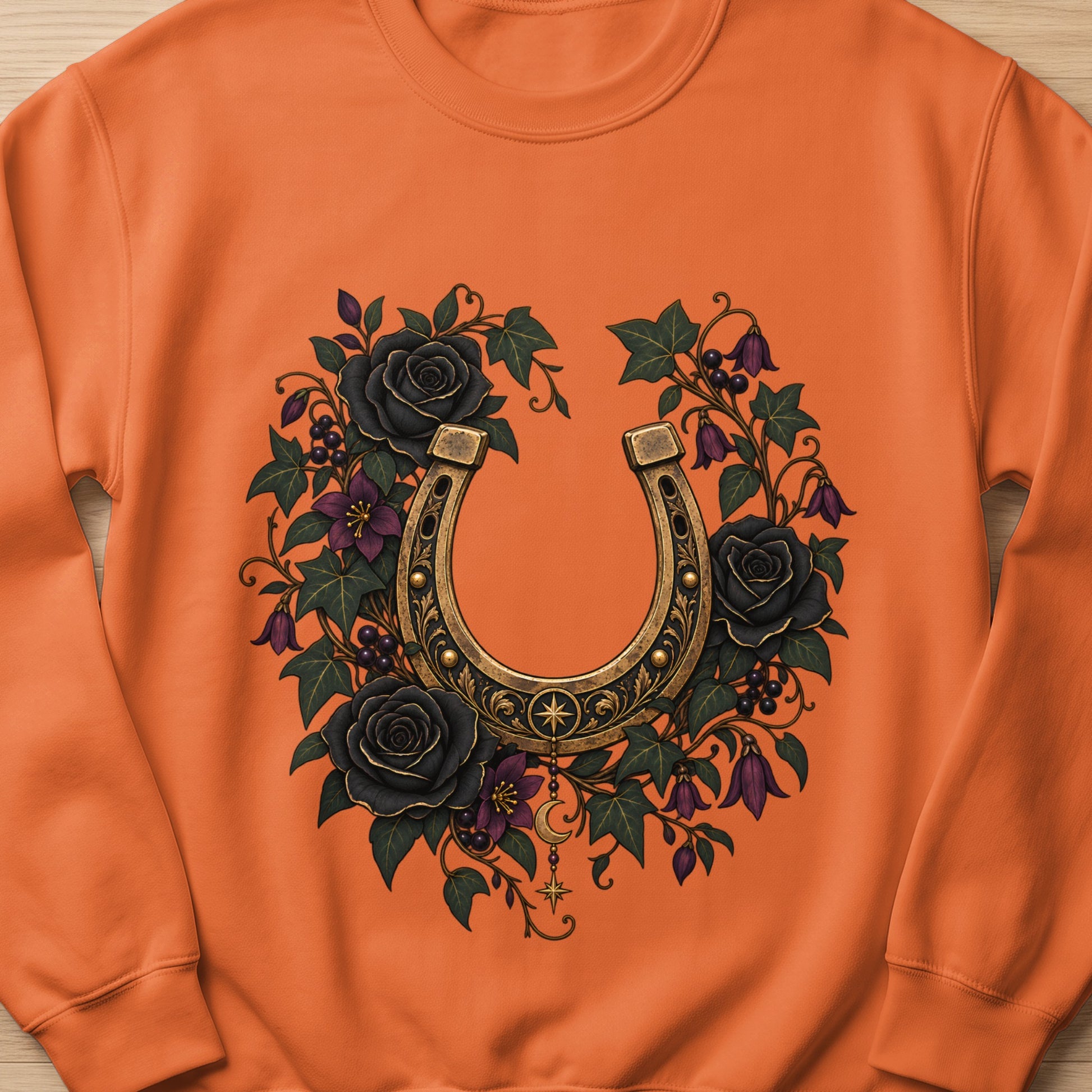 Orange sweatshirt with a vintage horseshoe surrounded by black roses and vines.