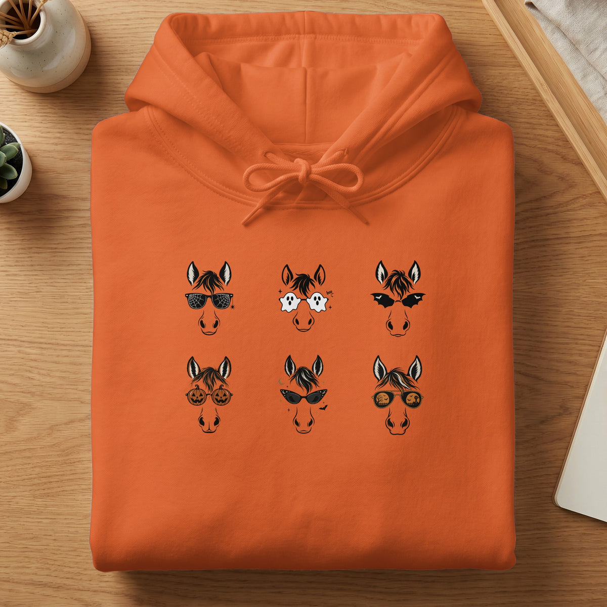 Orange hoodie featuring six horses wearing Halloween-themed sunglasses.