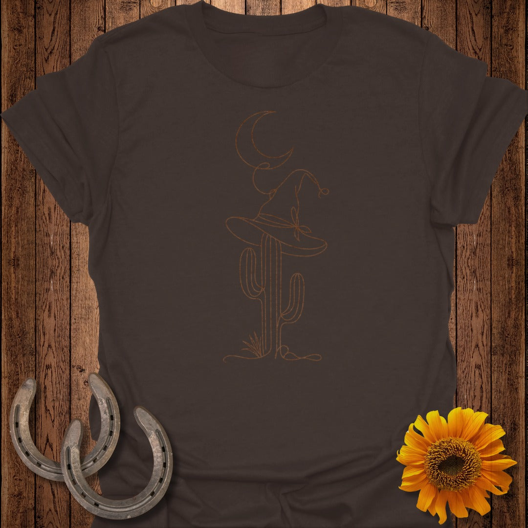 Brown t-shirt with line art of a witch hat on a cactus and a moon.