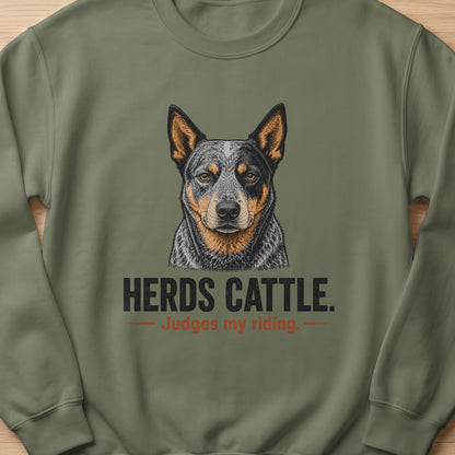 Crewneck sweatshirt with a drawing of an Australian Cattle Dog and text "HERDS CATTLE. Judges my riding."