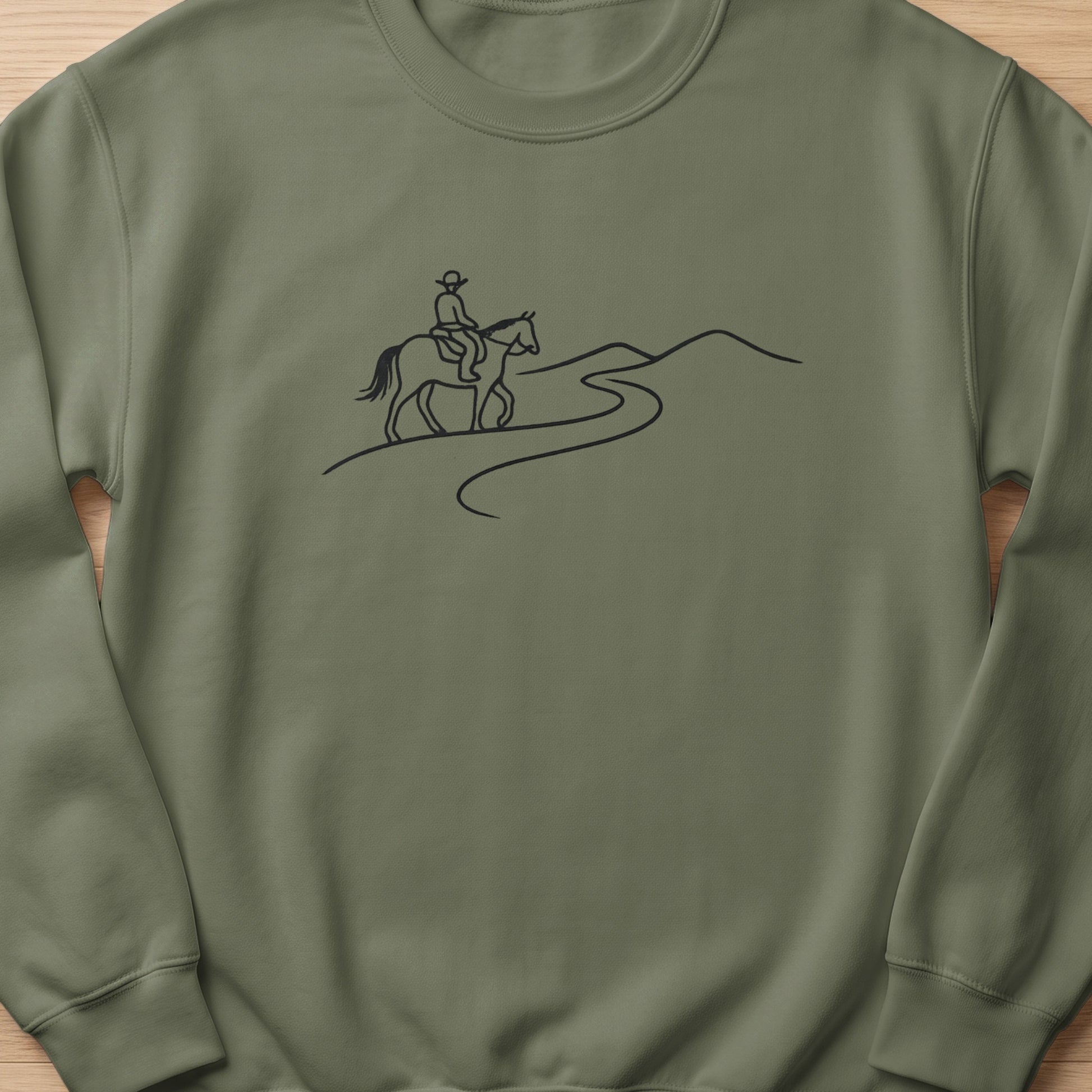 Line art of a person riding a horse on a winding path through hills.