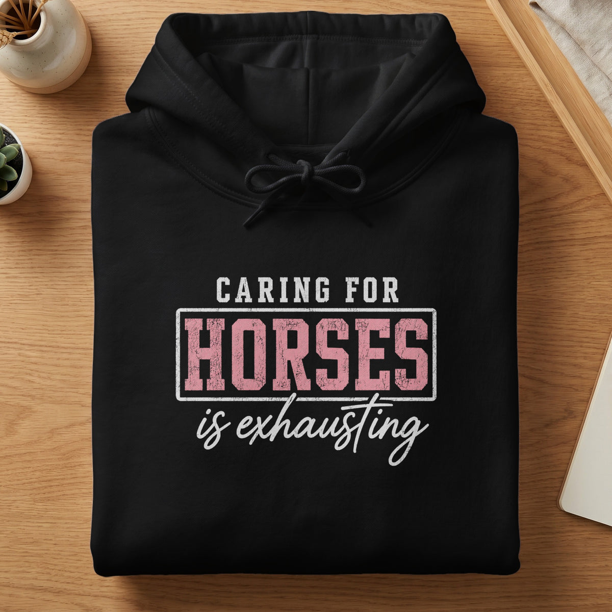 Black hoodie with "Caring For Horses is Exhausting" graphic print.