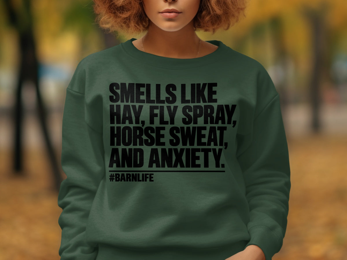 Green sweatshirt with black text: Smells like hay, fly spray, horse sweat, and anxiety. #Barnlife