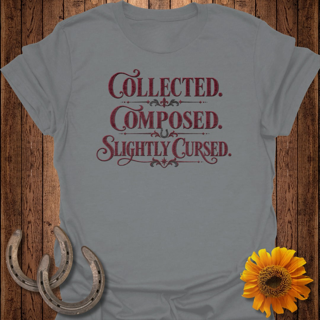 Grey t-shirt with "Collected. Composed. Slightly Cursed." text and decorative elements.