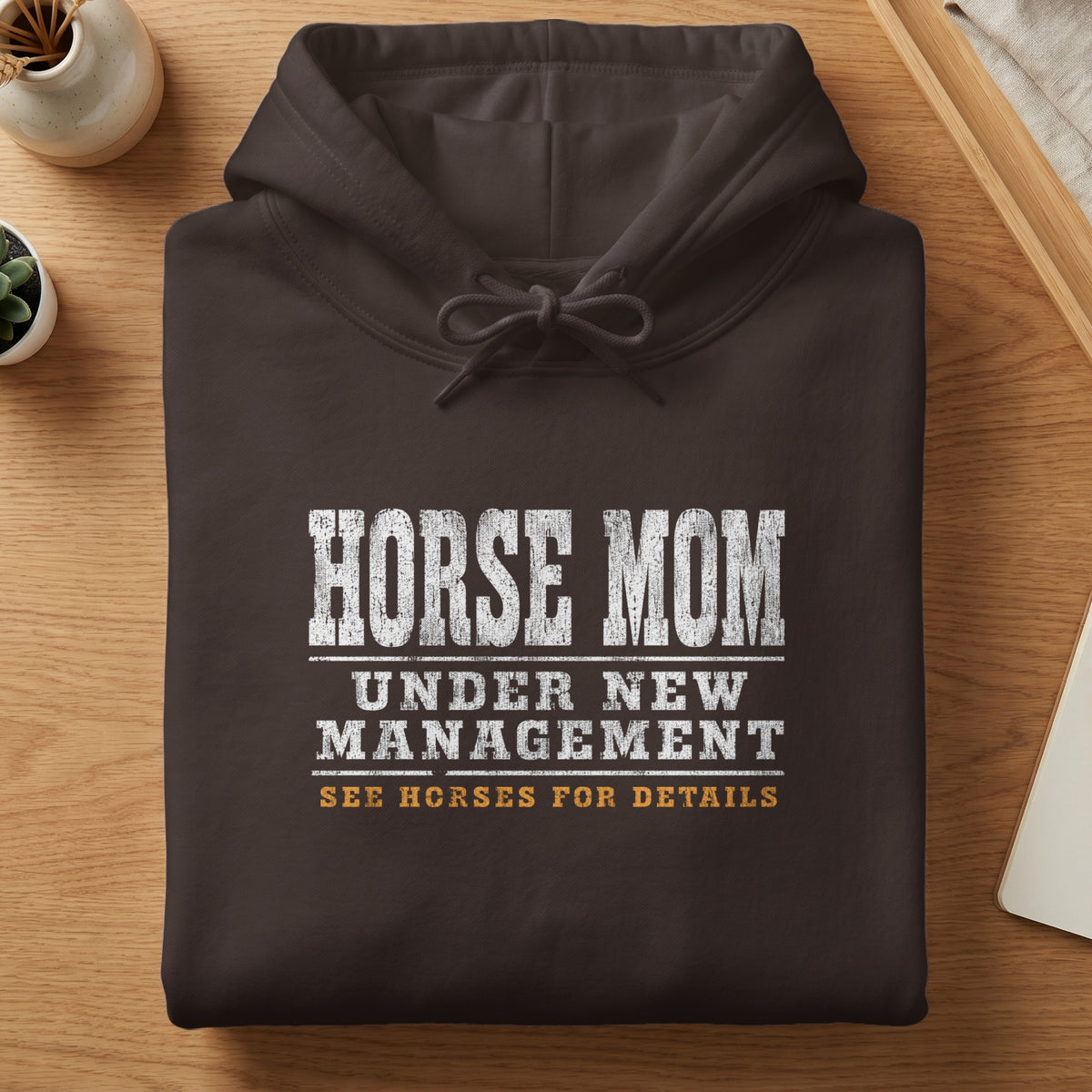 Dark brown hoodie with "HORSE MOM UNDER NEW MANAGEMENT SEE HORSES FOR DETAILS" text.