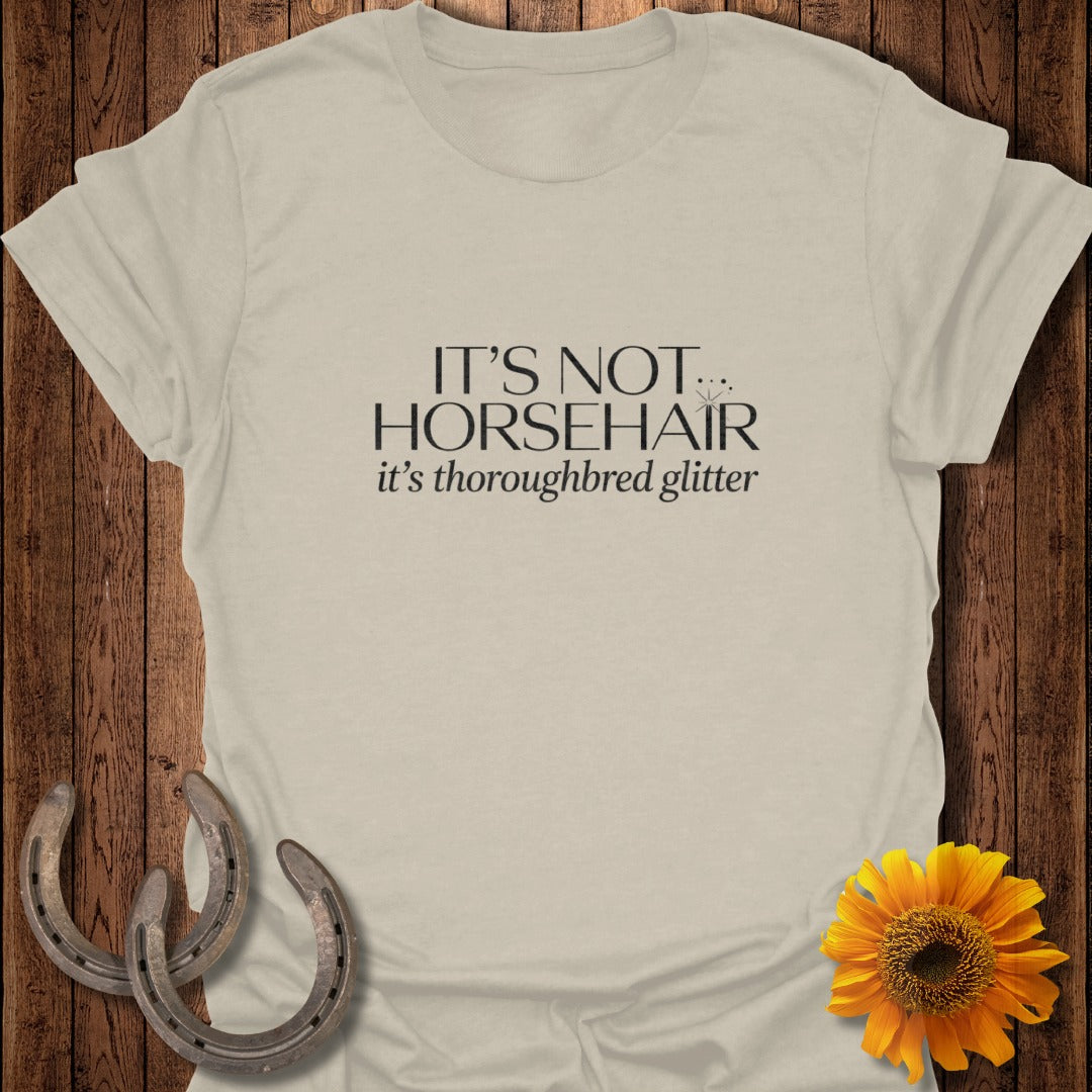 Light tan t-shirt with "IT'S NOT THOROUGHBRED glitter" text.