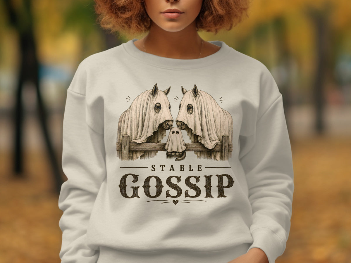 White sweatshirt with a "Stable Gossip" graphic featuring horses under ghost sheets.