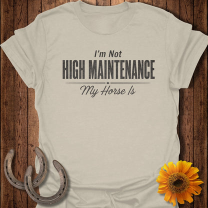 Light beige t-shirt with "I'm Not HIGH MAINTENANCE My Horse Is" text and horse shoes.