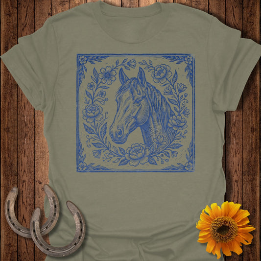 Blue horse head illustration with floral border on olive green t-shirt.