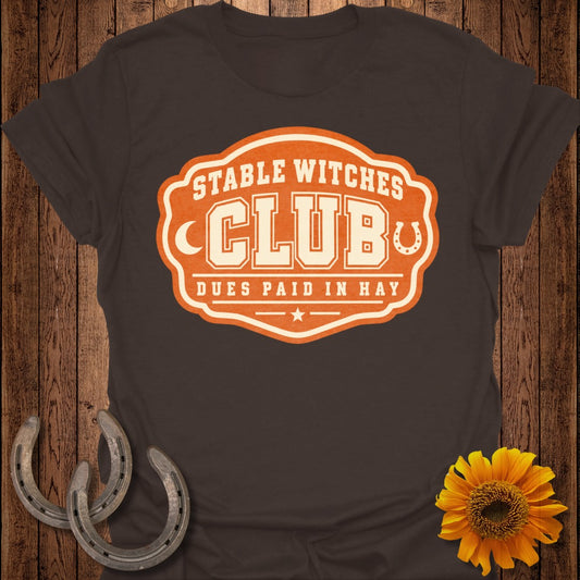 Brown t-shirt with "Stable Witches Club Dues Paid In Hay" graphic and horseshoes.