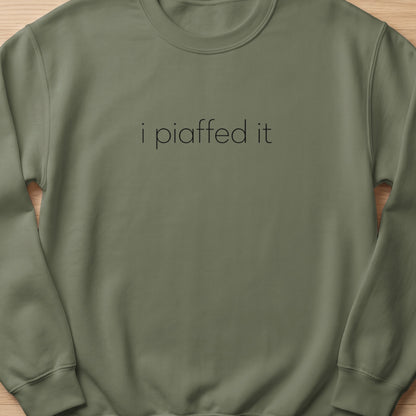 Olive green sweatshirt with black text "i piaffed it" on the chest.