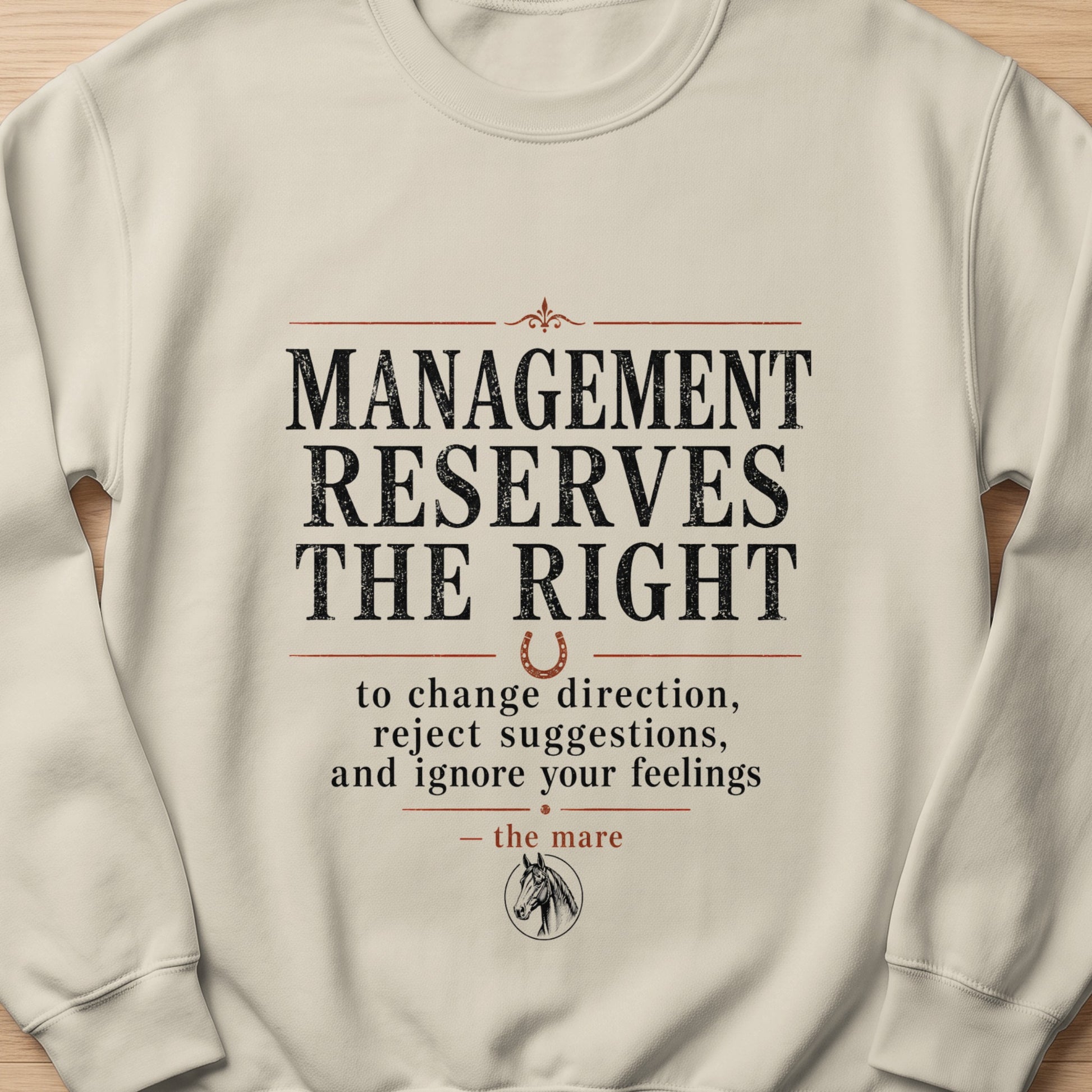 Cream sweatshirt with text "Management reserves the right to change direction, reject suggestions, and ignore your feelings - the mare".