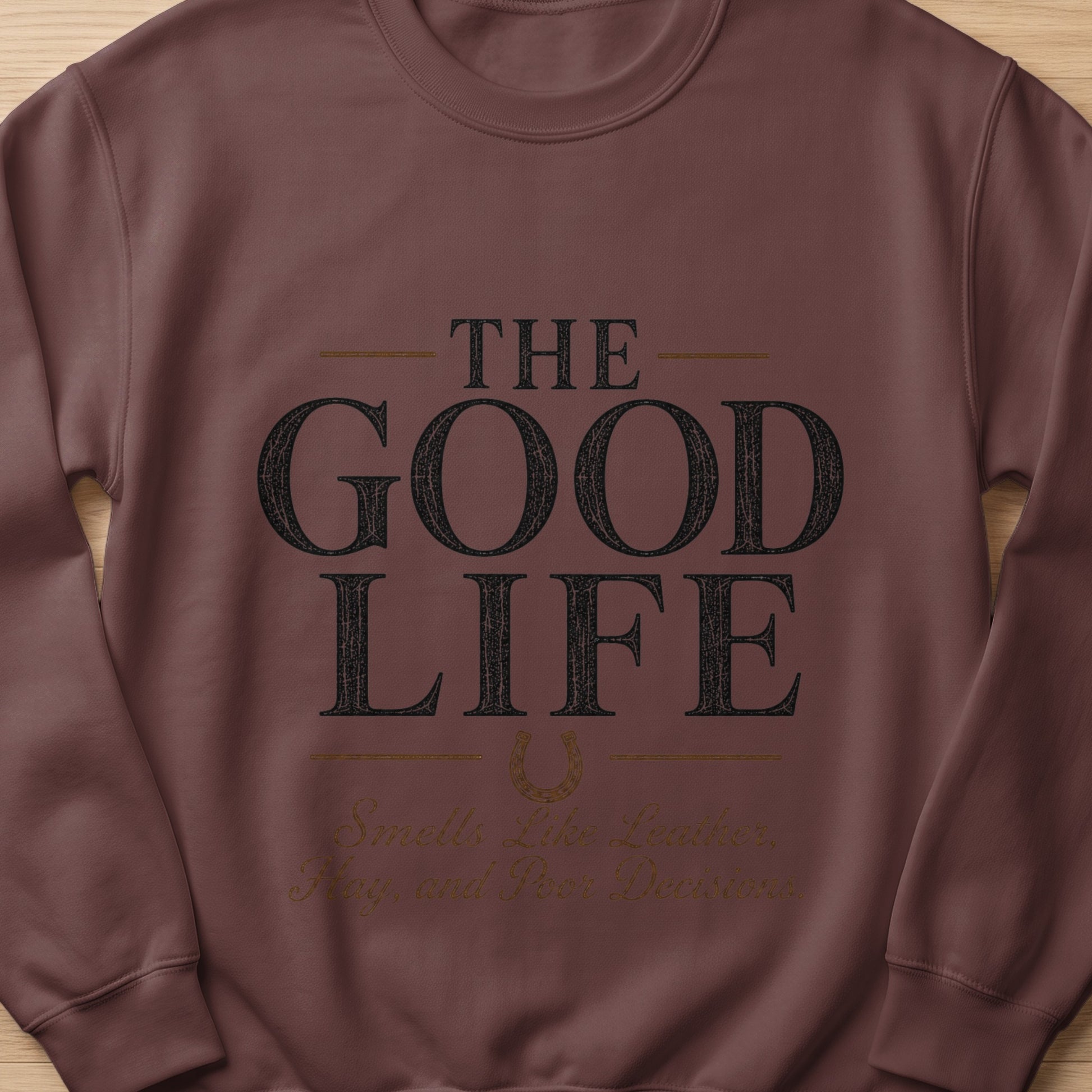 Brown sweatshirt with "The Good Life" and "Smells Like Leather, Hay, and Poor Decisions" text.