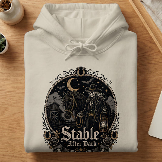 Cream hoodie with "Stable After Dark" graphic featuring a skeleton cowboy, horse, and barn.