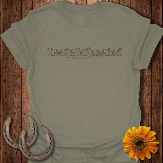 Olive green t-shirt with a line of horses graphic and "started with one" text.