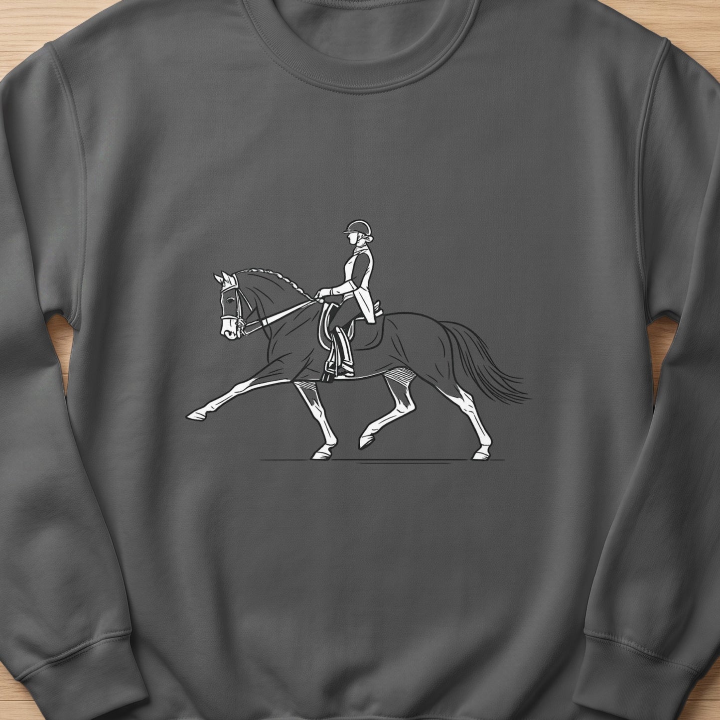Line art of a dressage rider and horse in motion on a gray sweatshirt.