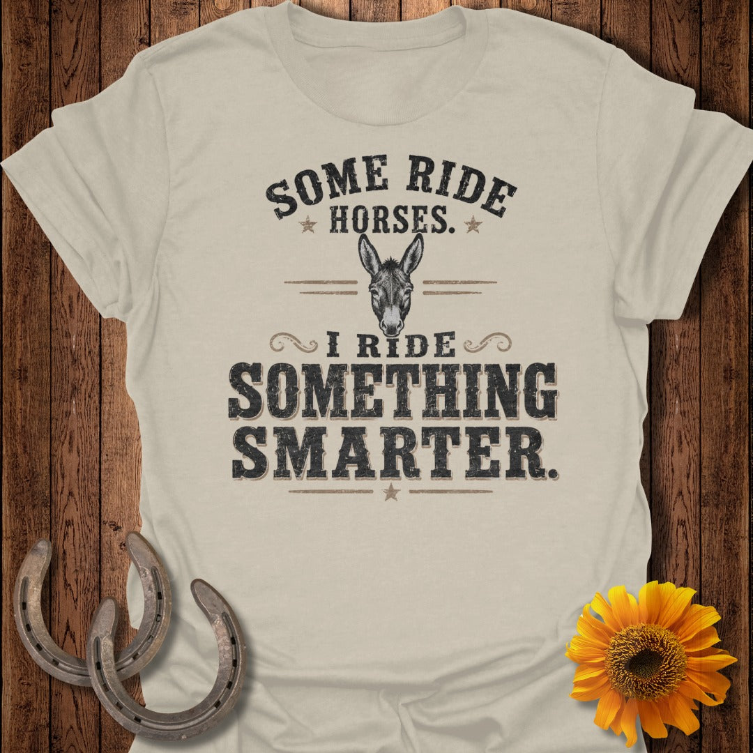 Light beige t-shirt with "Some Ride Horses. I Ride Something Smarter." text and a donkey graphic.