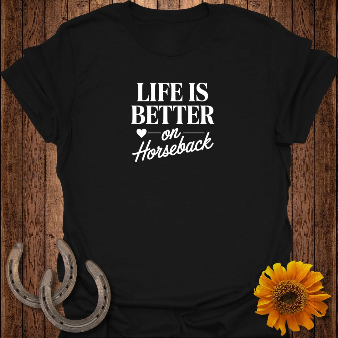 Black t-shirt with white text "Life is better on horseback" and decorative horseshoes.