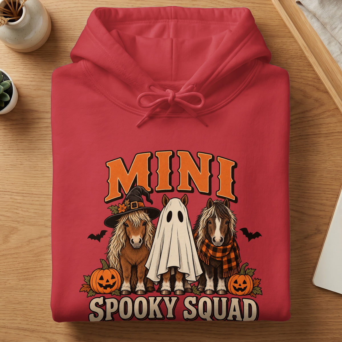 Red hoodie with "MINI SPOOKY SQUAD" text and three horses in Halloween costumes.