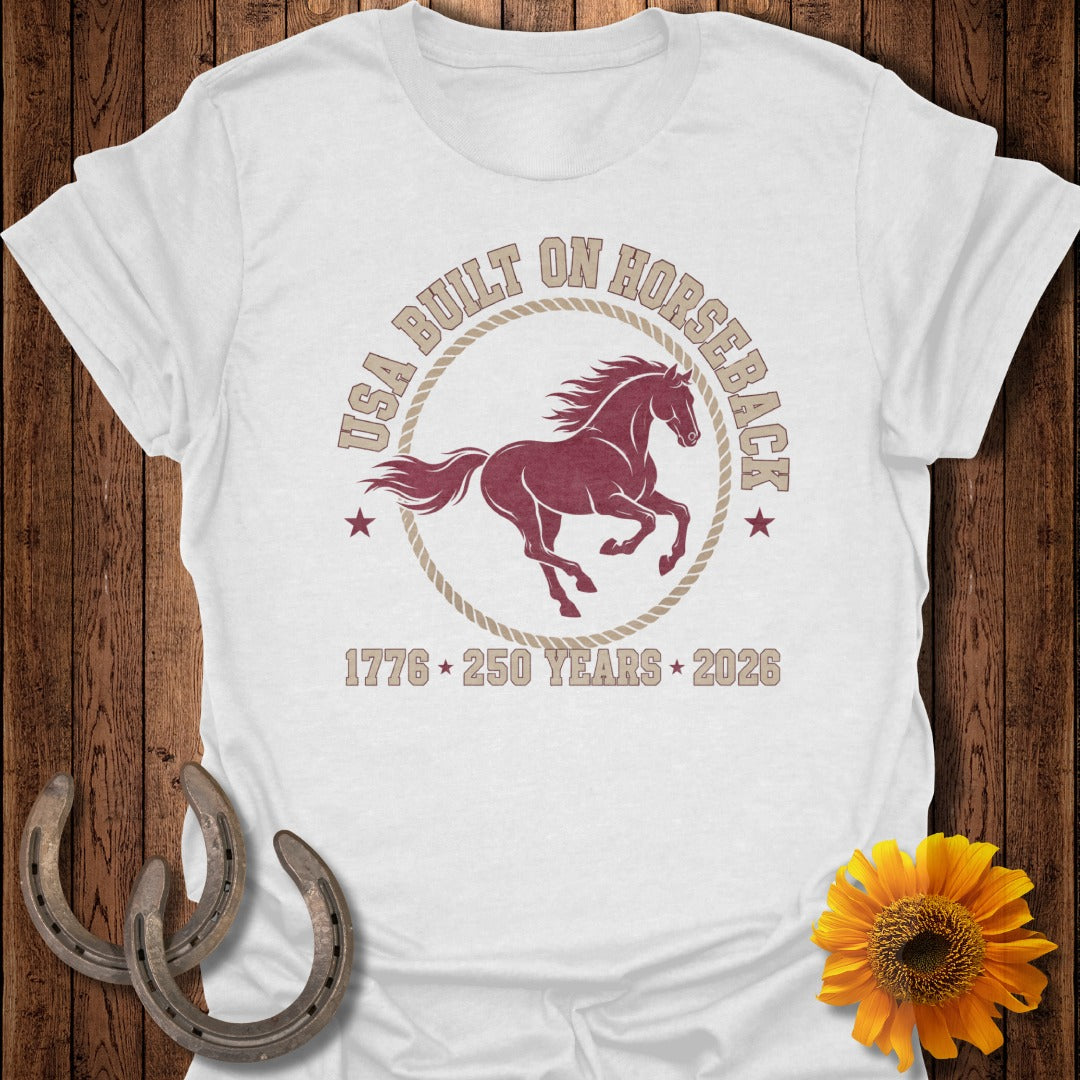 White t-shirt with maroon horse graphic and text USA BUILT ON HORSEBACK 1776 250 YEARS 2026.
