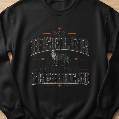 Black sweatshirt with text "MY HEELER RUNS THIS TRAILHEAD" and a dog illustration.