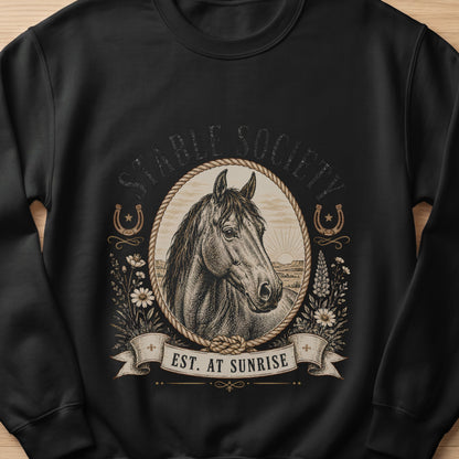 Black sweatshirt with vintage horse head emblem and text "EST. AT SUNRISE".
