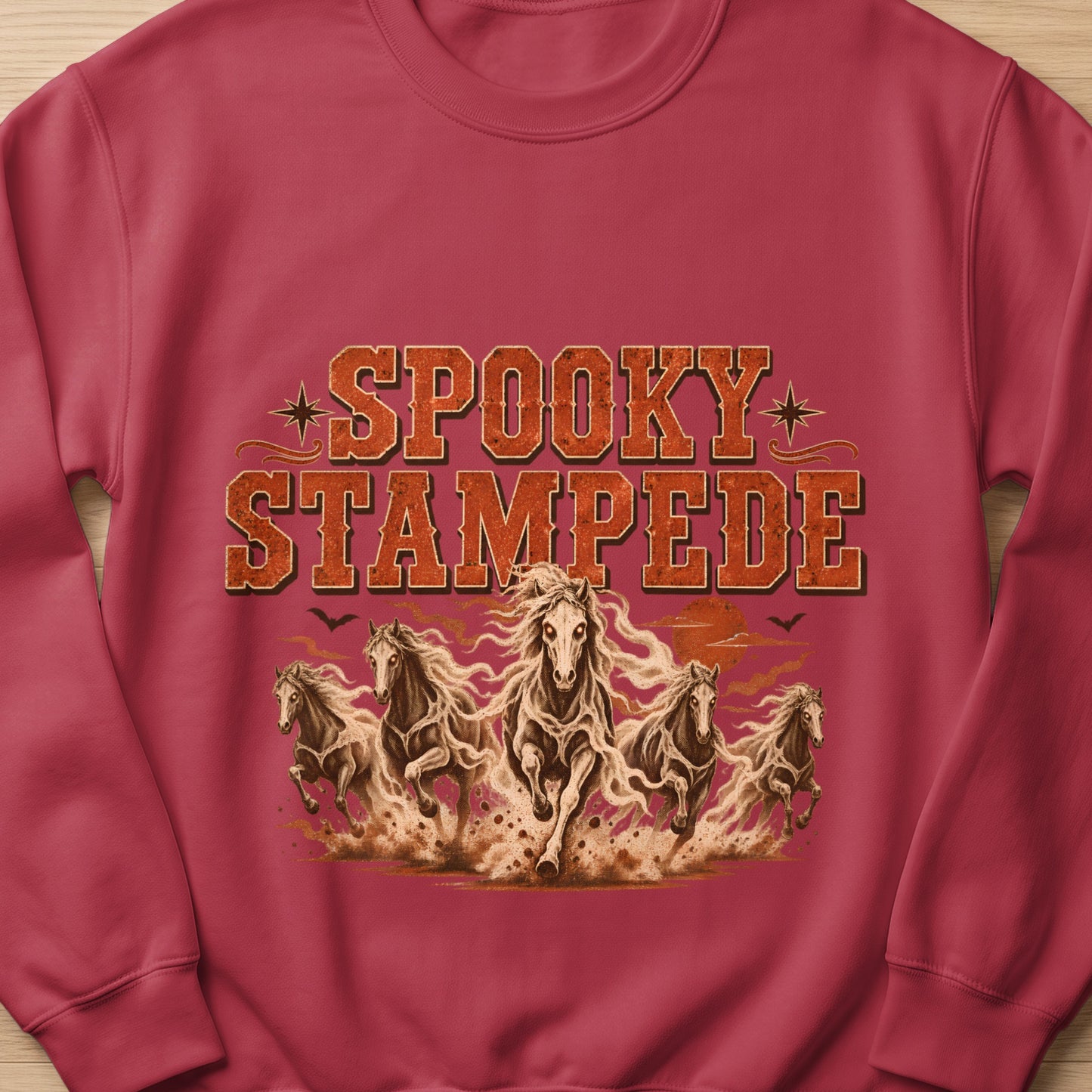 Crewneck sweatshirt with "SPOOKY STAMPEDE" text and galloping horses illustration.