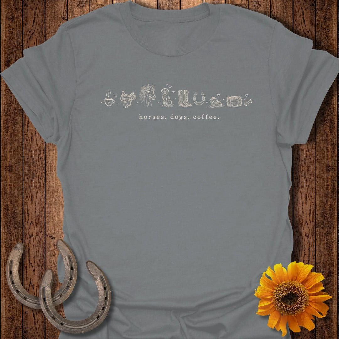 Grey t-shirt with line art of horseshoes, horses, dogs, and coffee cup.