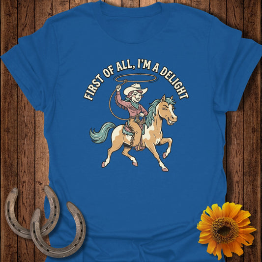 Blue t-shirt with cartoon cowboy girl on horse, "First of all, I'm a delight" text.