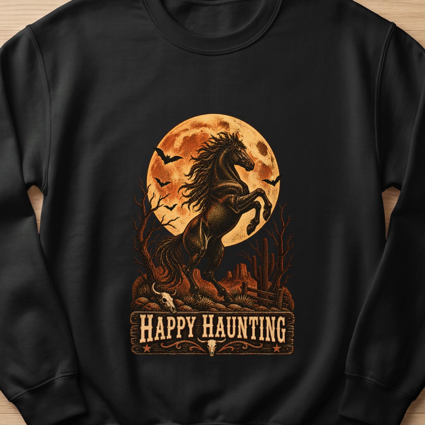 Black sweatshirt with a Halloween desert scene and "Happy Haunting" text.