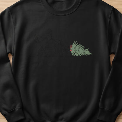 Black sweatshirt with a line art design of a person riding a horse pulling a Christmas tree.