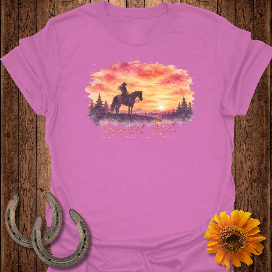 Silhouette of person riding horse at sunset with "Sunset Ride" text on pink t-shirt.