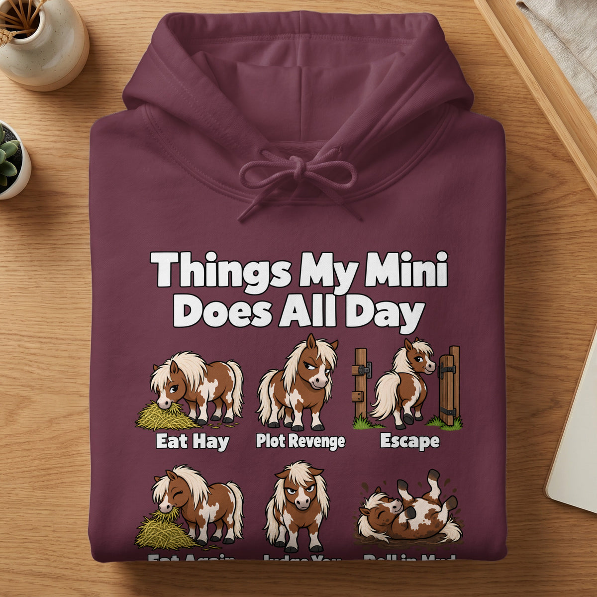 A maroon hooded sweatshirt printed with a funny graphic of a miniature horse and daily activities.