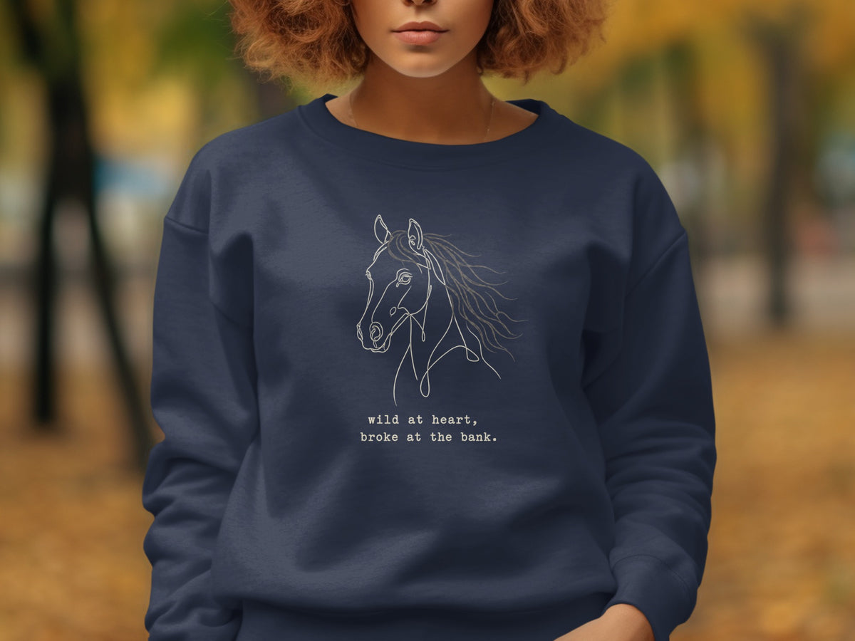 Navy sweatshirt with white line drawing of a horse and text: "wild at heart, broke at the bank."
