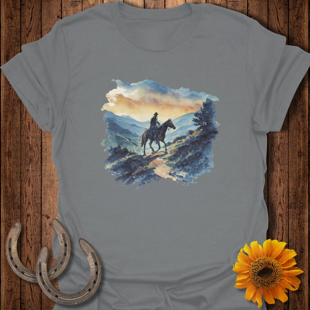Cowboy on horseback rides through a scenic mountain landscape at sunset.