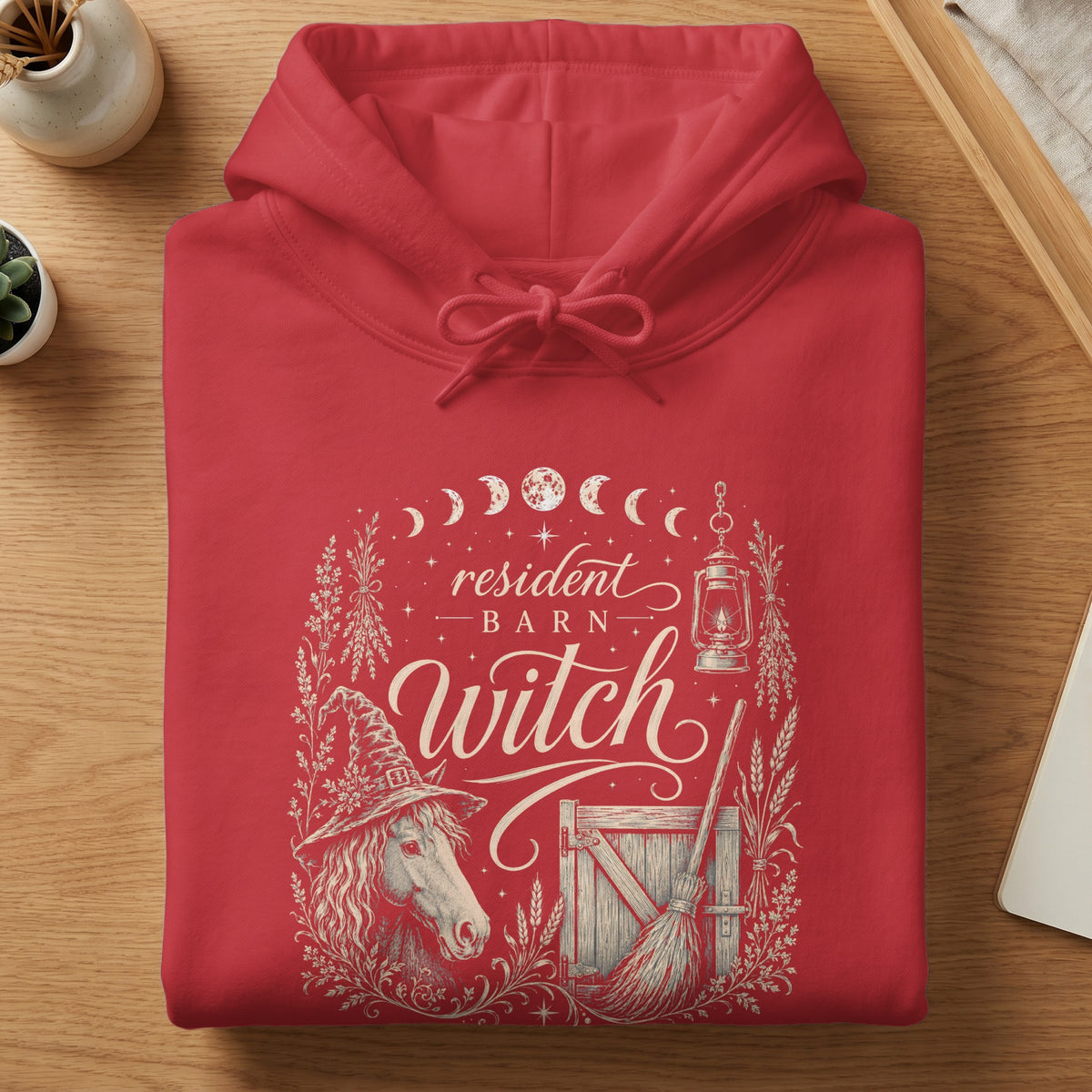 Red hoodie with "Resident Barn Witch" design featuring a horse, barn, broom, and lantern.