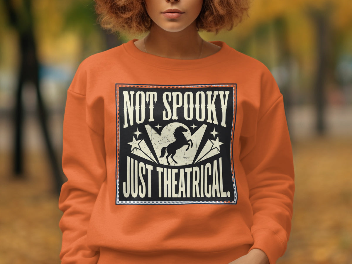 Orange sweatshirt with "NOT SPOOKY JUST THEATRICAL" and a silhouette of a rearing horse.