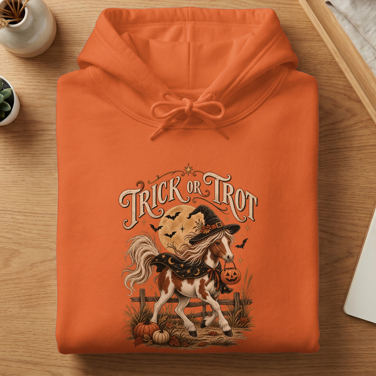 Orange hoodie with "Trick or Trot" text, a horse in a witch hat, and pumpkins.