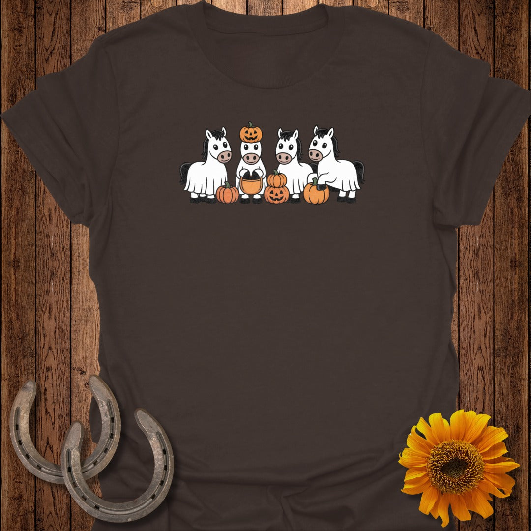Four horses in ghost costumes holding pumpkins and jack-o'-lanterns.