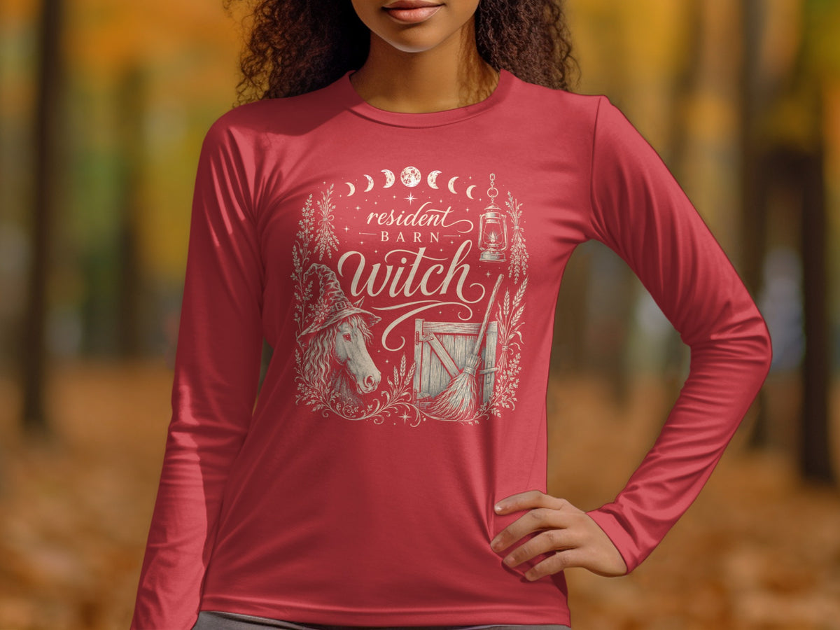 Red long-sleeve shirt with "resident barn witch" graphic featuring a horse, broom, and lantern.