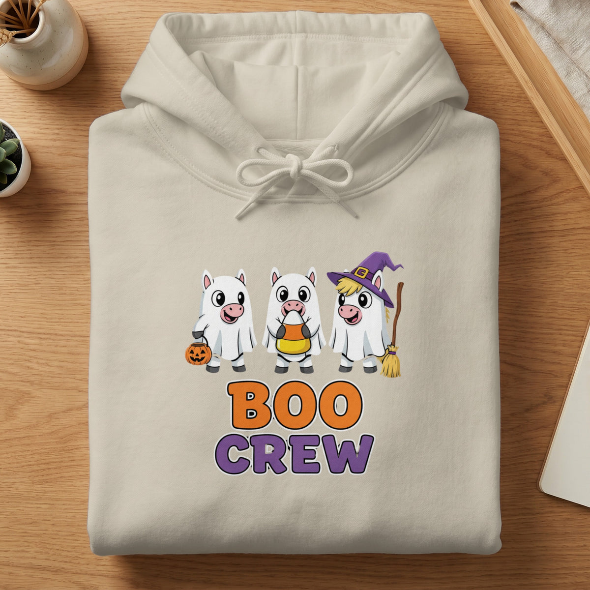 Cream hoodie with "Boo Crew" text and cartoon unicorns in Halloween costumes.