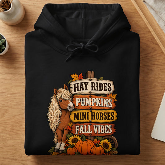 Black hoodie with fall-themed graphic of a mini horse, pumpkins, sunflowers, and signs.
