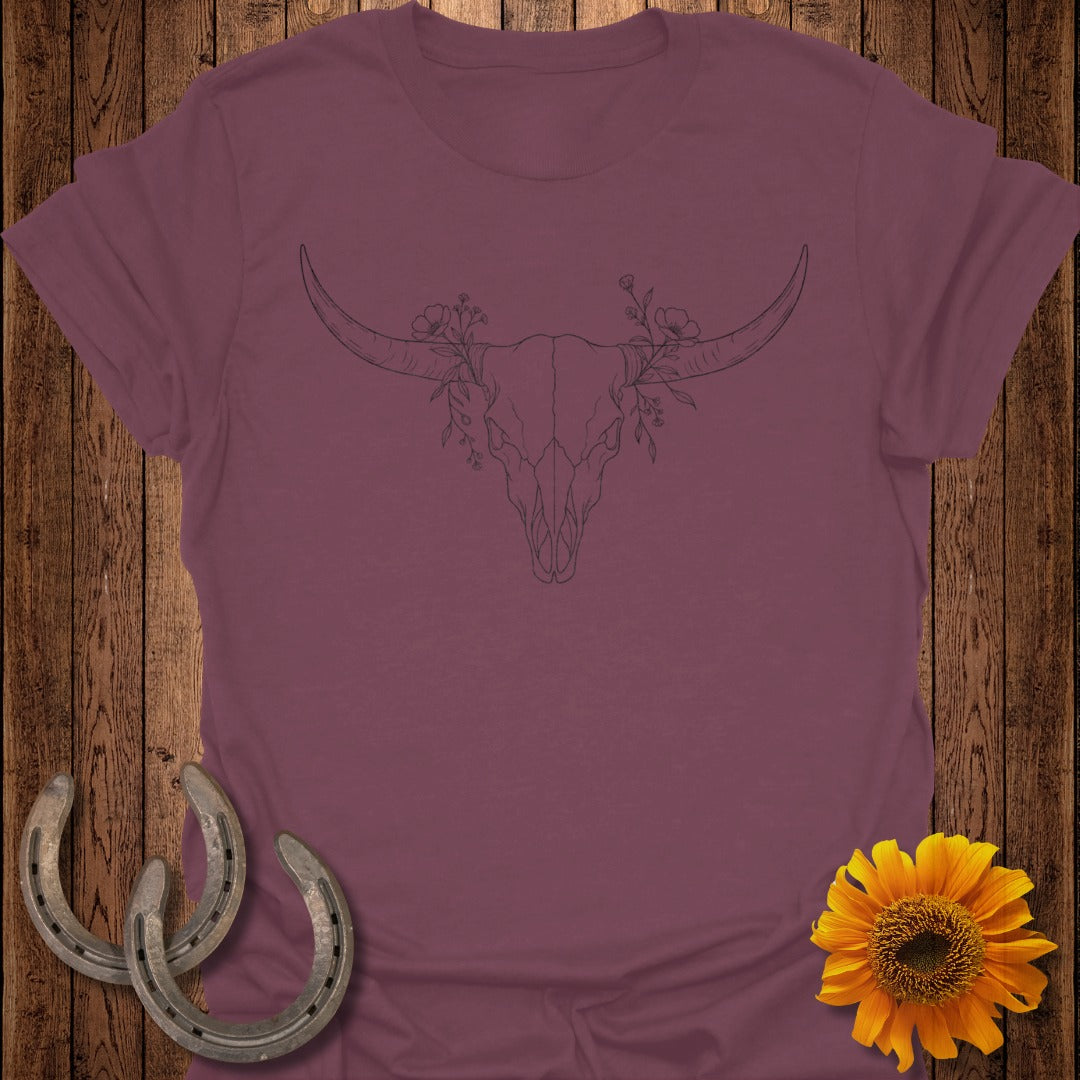 Burgundy t-shirt with line art of a bull skull with flowers, horseshoes, and sunflower.