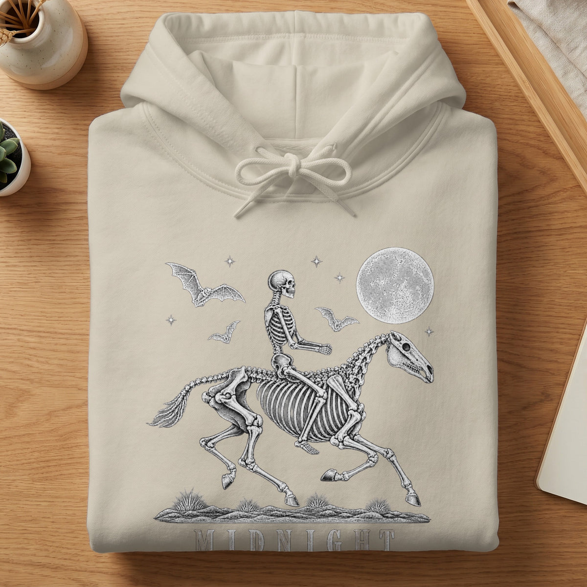 Beige hoodie with skeleton rider on horse, bats, moon, and "MIDNIGHT" text.