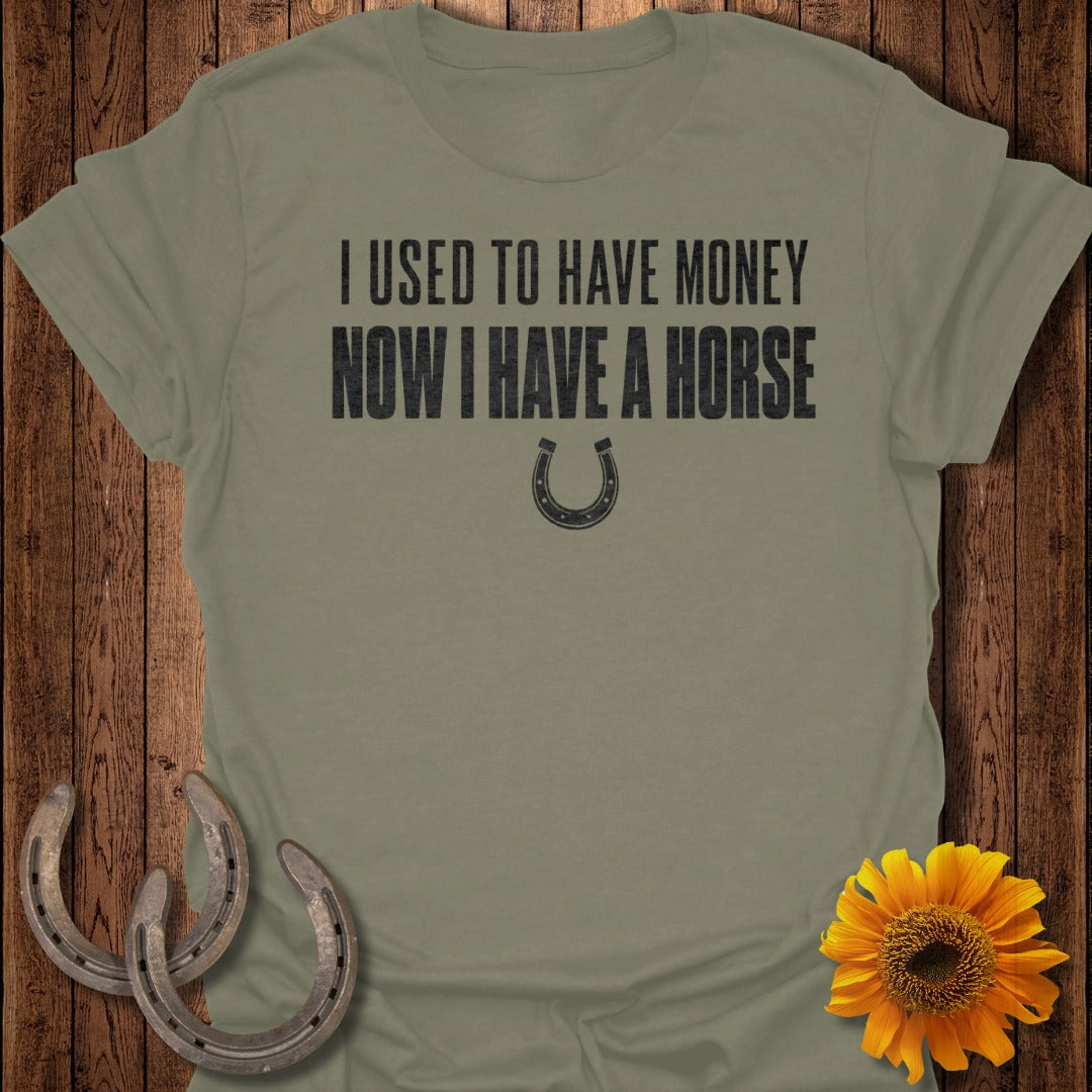 Olive green t-shirt with black text "I USED TO HAVE MONEY NOW I HAVE A HORSE" and a horseshoe.