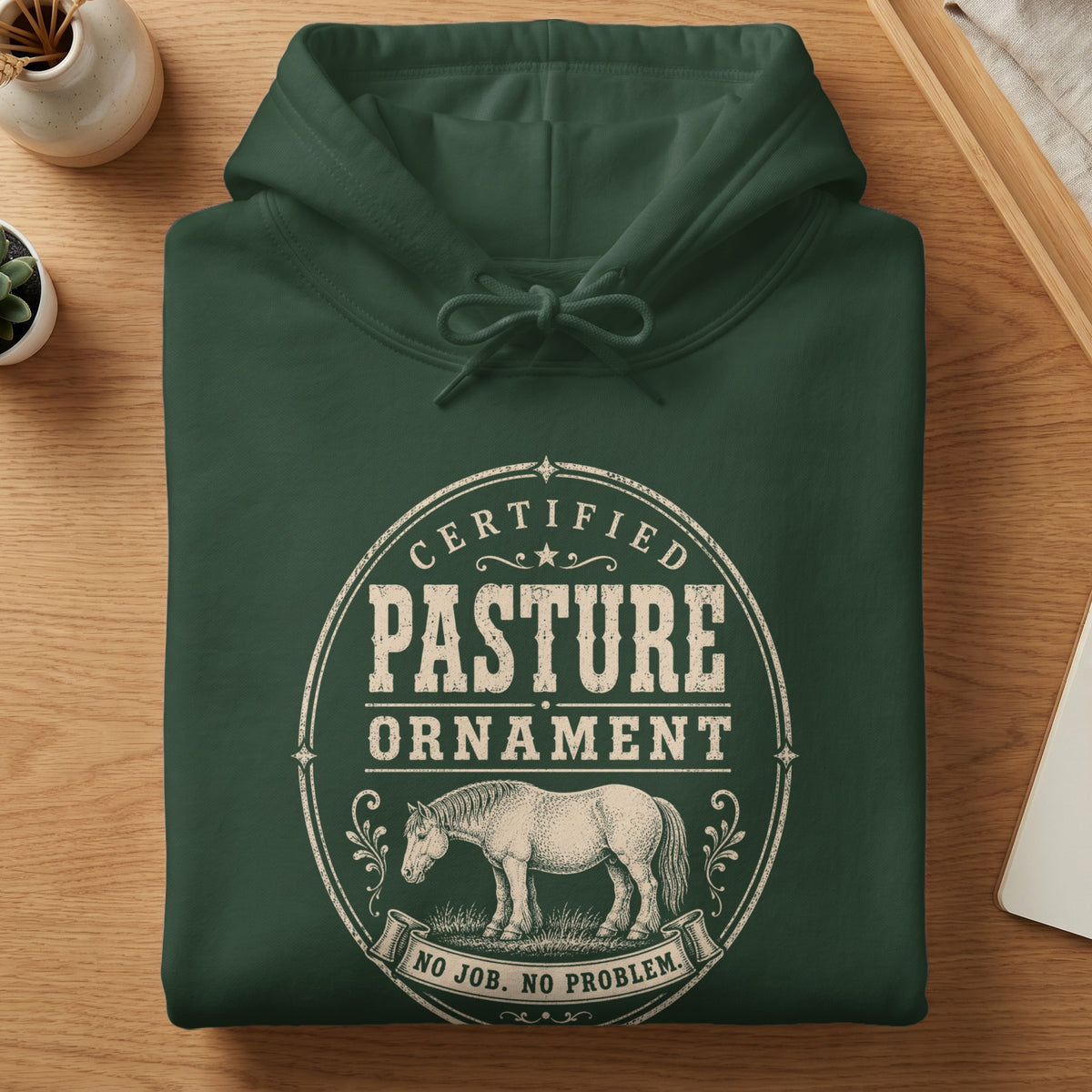 Dark green hoodie with "Certified Pasture Ornament No Job. No Problem." text and horse graphic.