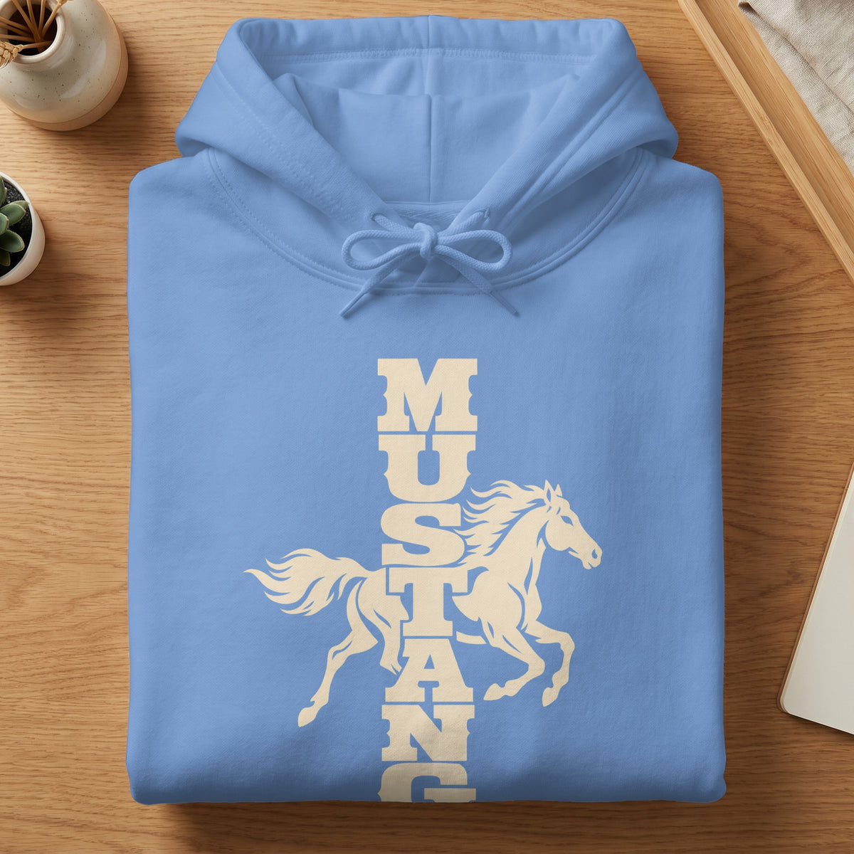 A folded light blue hooded sweatshirt features a white graphic of a galloping horse with the word Mustang.