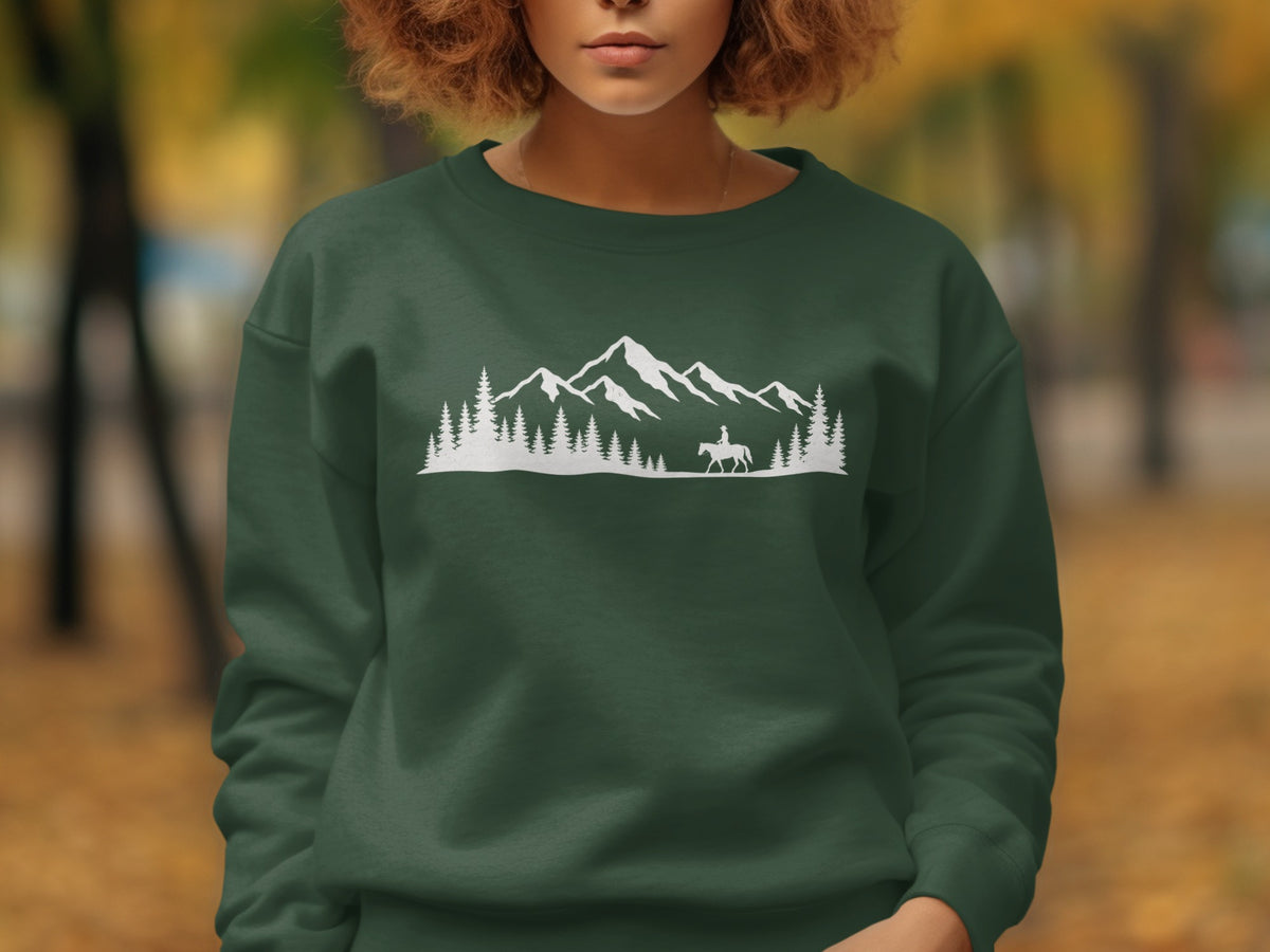 Dark green sweatshirt with white mountain, tree, and rider silhouette graphic.