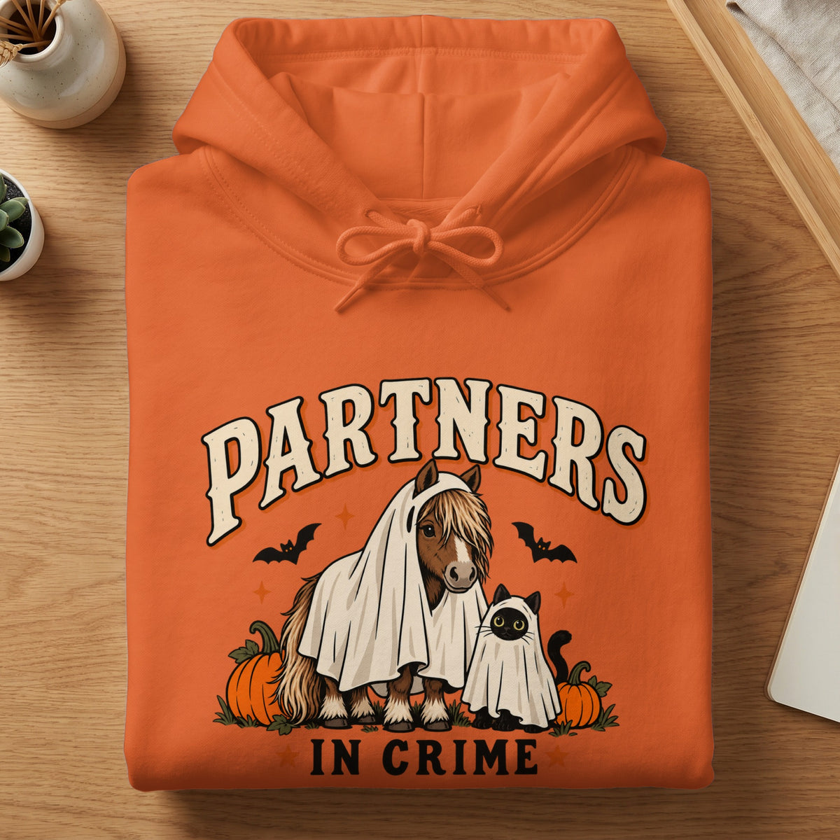 Orange hoodie with "Partners In Crime" text and a horse and cat in ghost costumes.