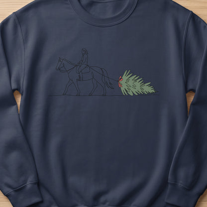 Line art of a rider on horseback pulling a Christmas tree with a red bow.